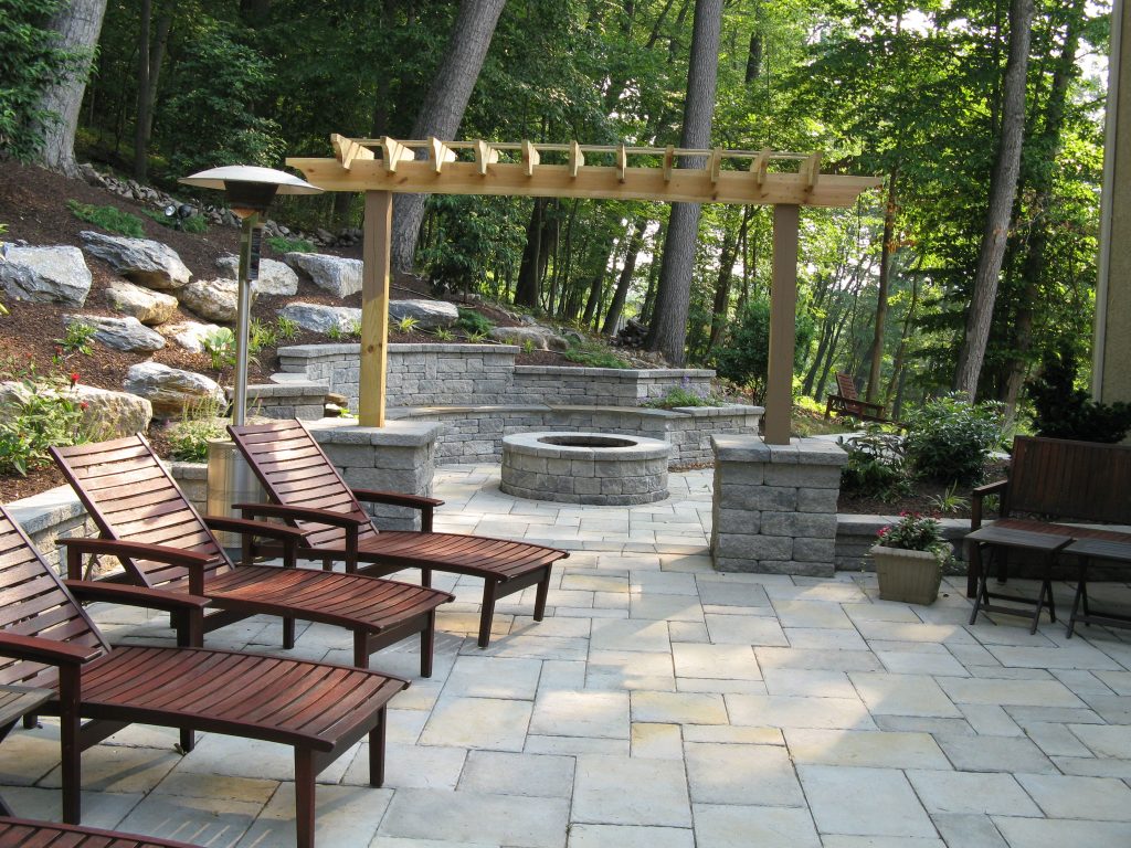 Stone living area with built in fireplace and pergola